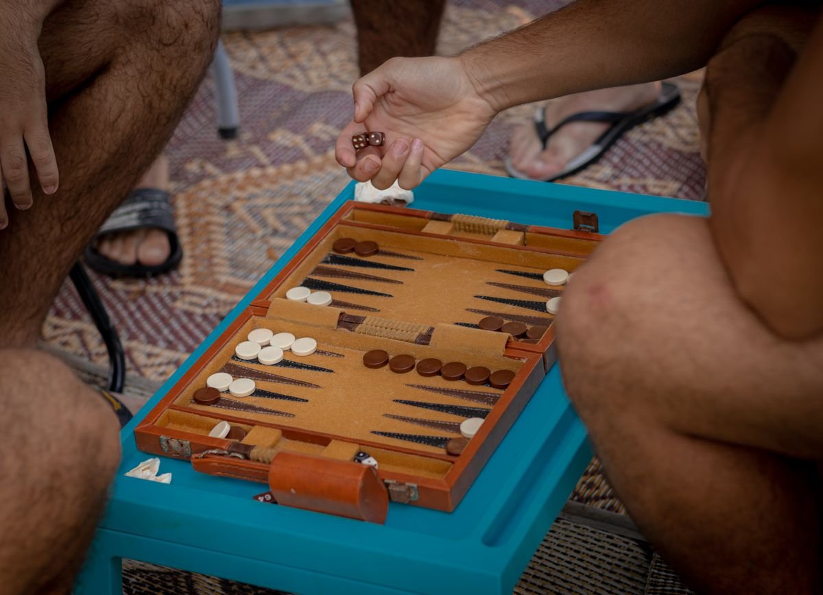 Two people sitting across from each other playing a board game