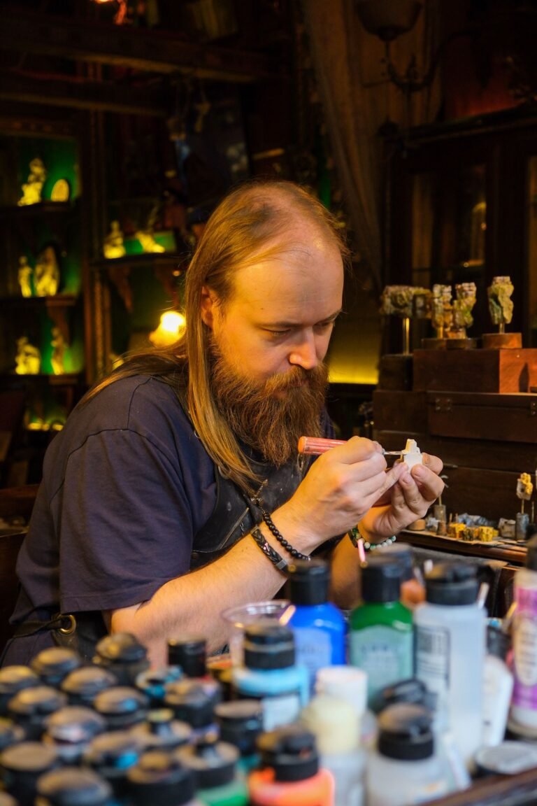 Hobbyist painting miniature figurines in a workshop