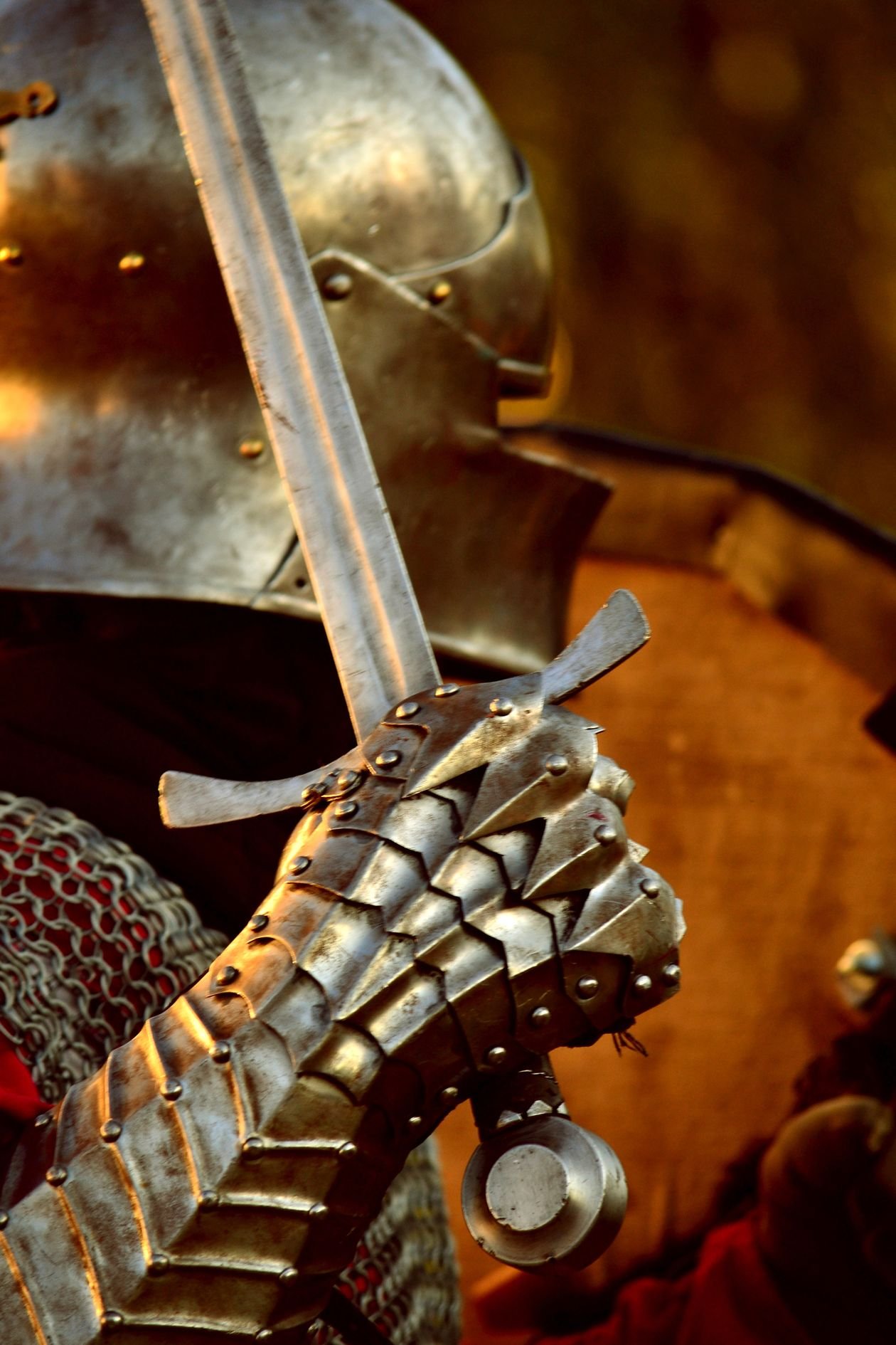 A medieval knight's steel gauntlet gripping a sword