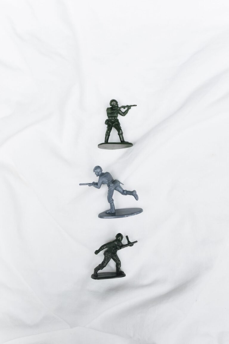 Plastic toy soldier figurines arranged on a white surface, seen from above