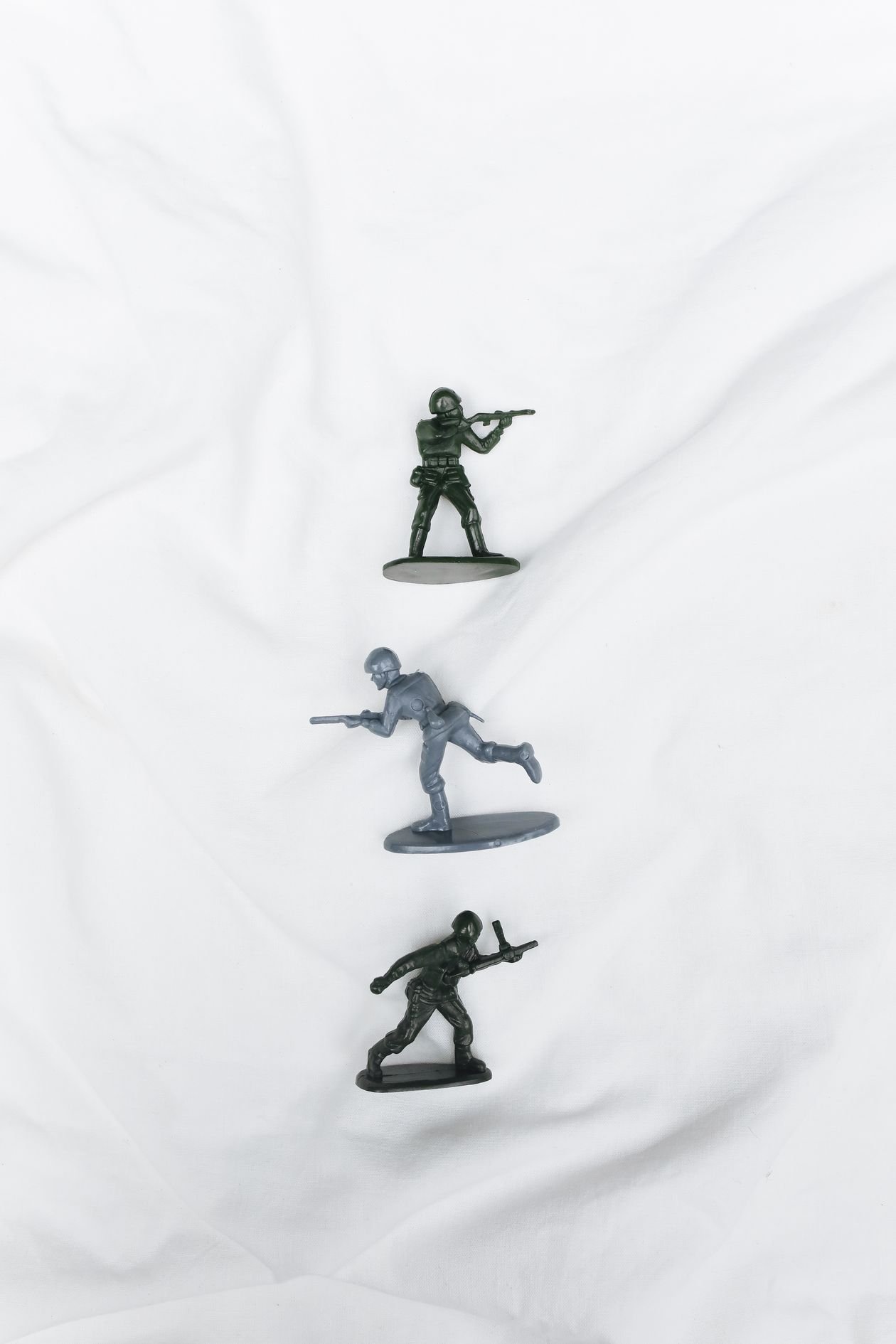 Plastic toy soldier figurines arranged on a white surface, seen from above