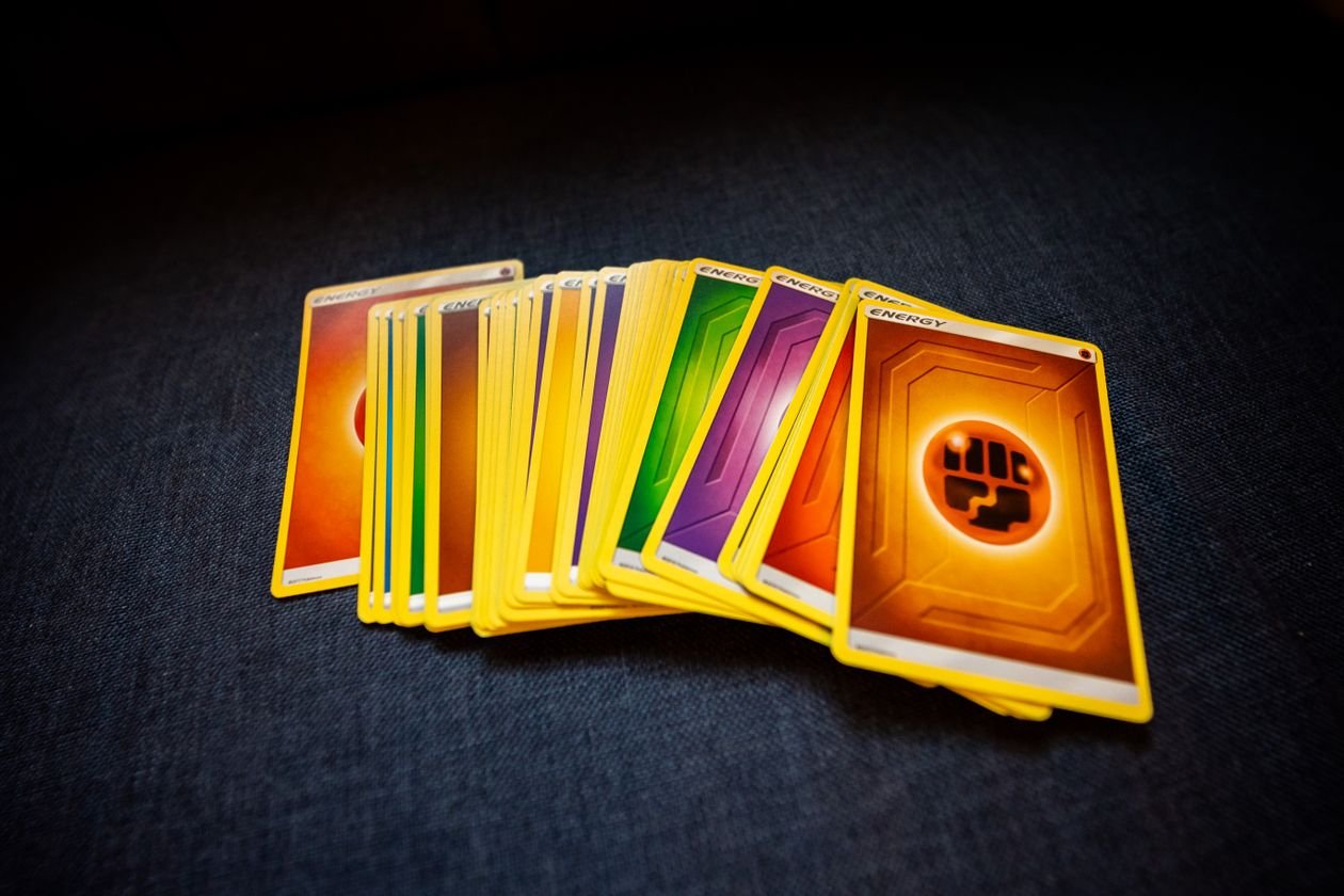 Overhead view of a stack of colorful collectible trading cards on a dark surface