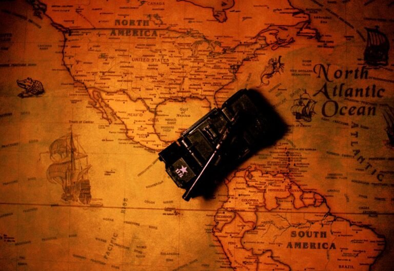 A toy tank sitting on top of a vintage map